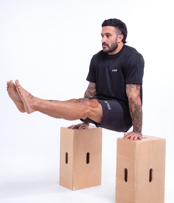 Man performing a controlled strength exercise in a minimalist dark gym.